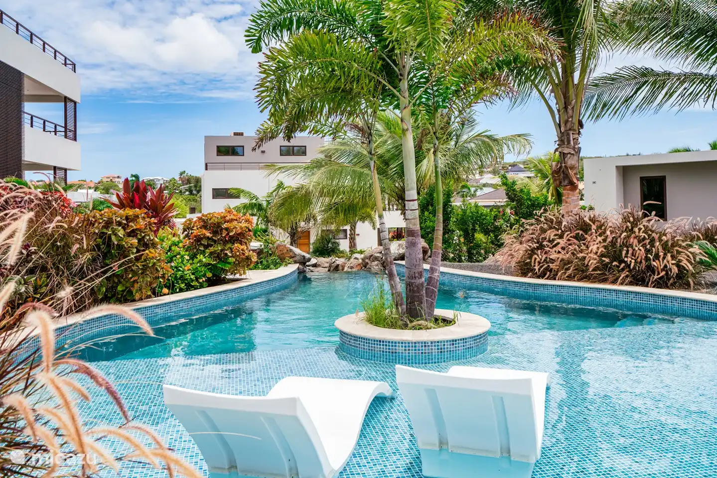 Zwembad met heerlijke ligbedjes in het water