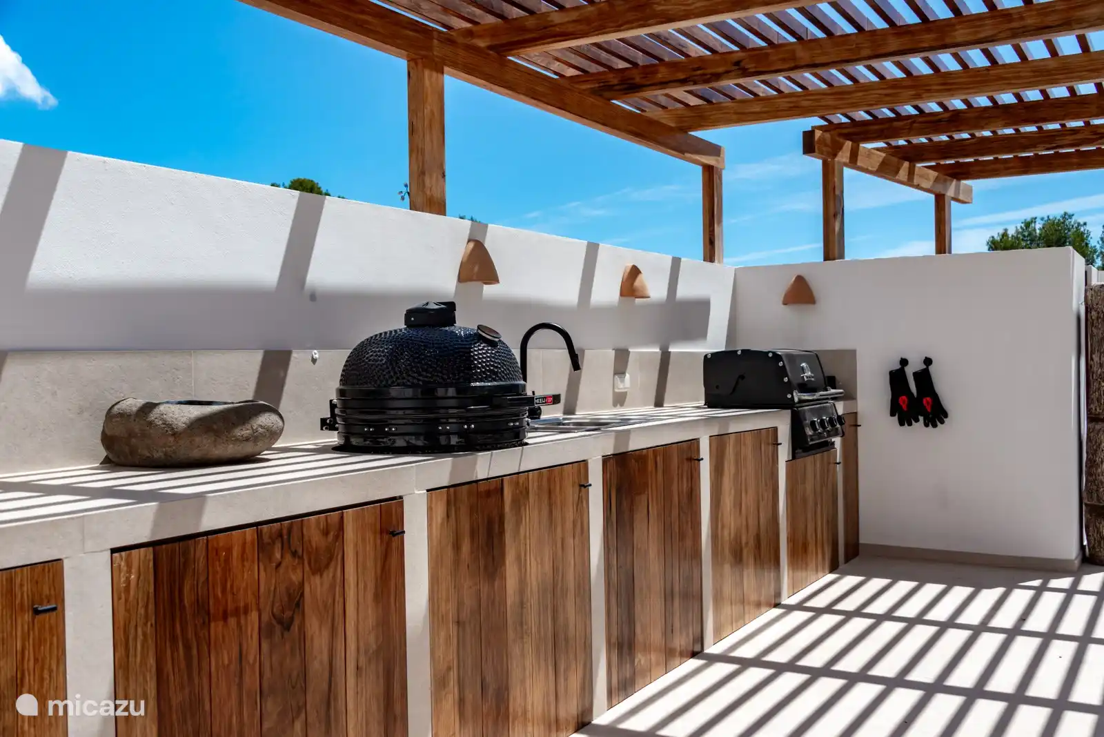 Die Außenküche ist mit einem holzbefeuerten Pizzaofen, einem Green-Egg, einem Gasgrill und Gasbrennern ausgestattet. Außerdem gibt es einen Kühlschrank und eine Spülmaschine.