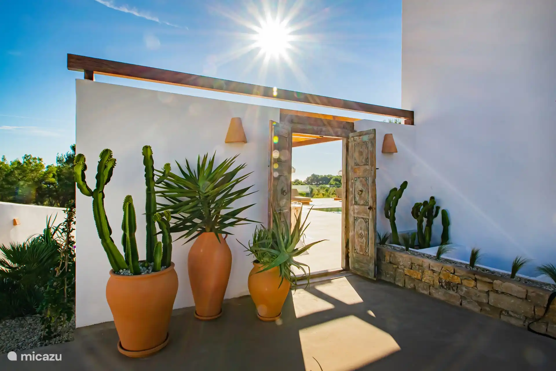 Vom Parkplatz aus gehen Sie durch die antiken Holztüren auf die Terrasse.