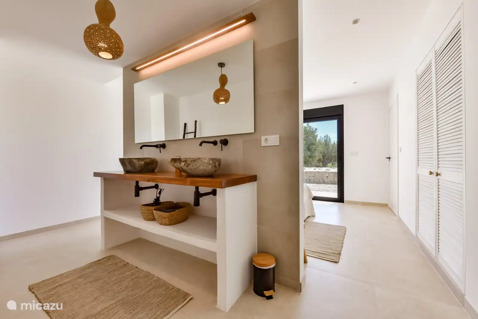 Jedes Schlafzimmer verfügt über einen Badezimmerschrank aus Teakholz mit Natursteinwaschbecken und einem großen beleuchteten Spiegel.