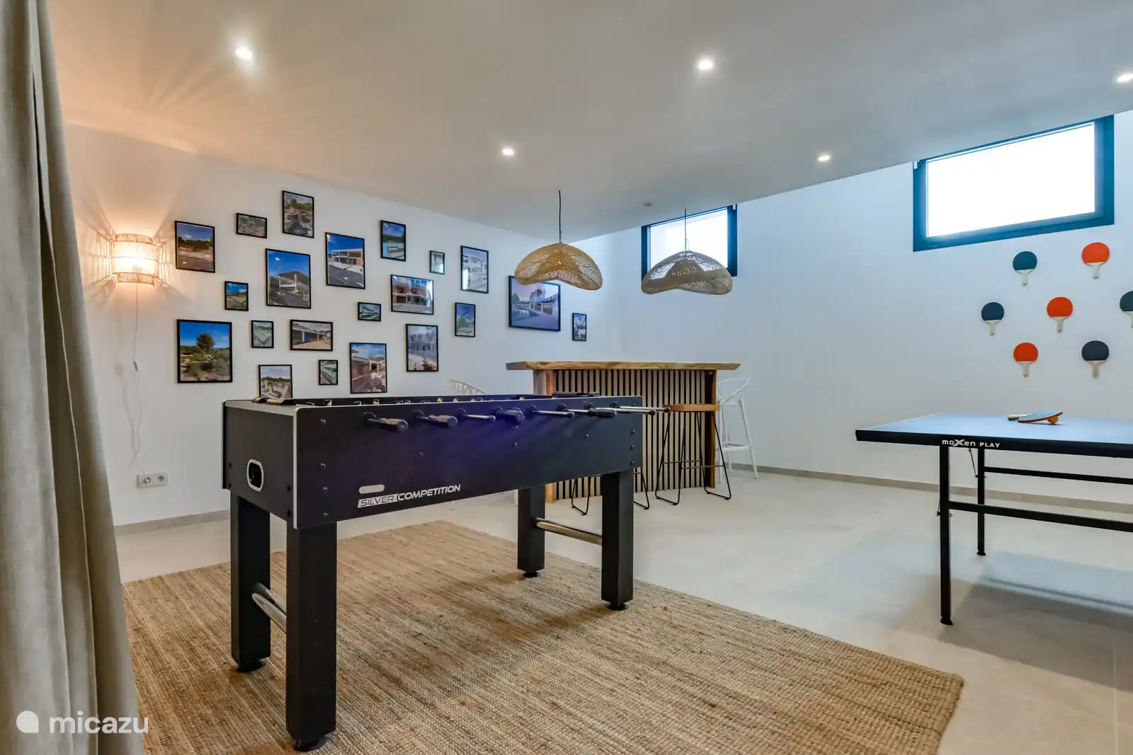 In dem großen Raum im Erdgeschoss gibt es neben einer Bar und einem Kickertisch auch eine Dartscheibe und eine Tischtennisplatte.