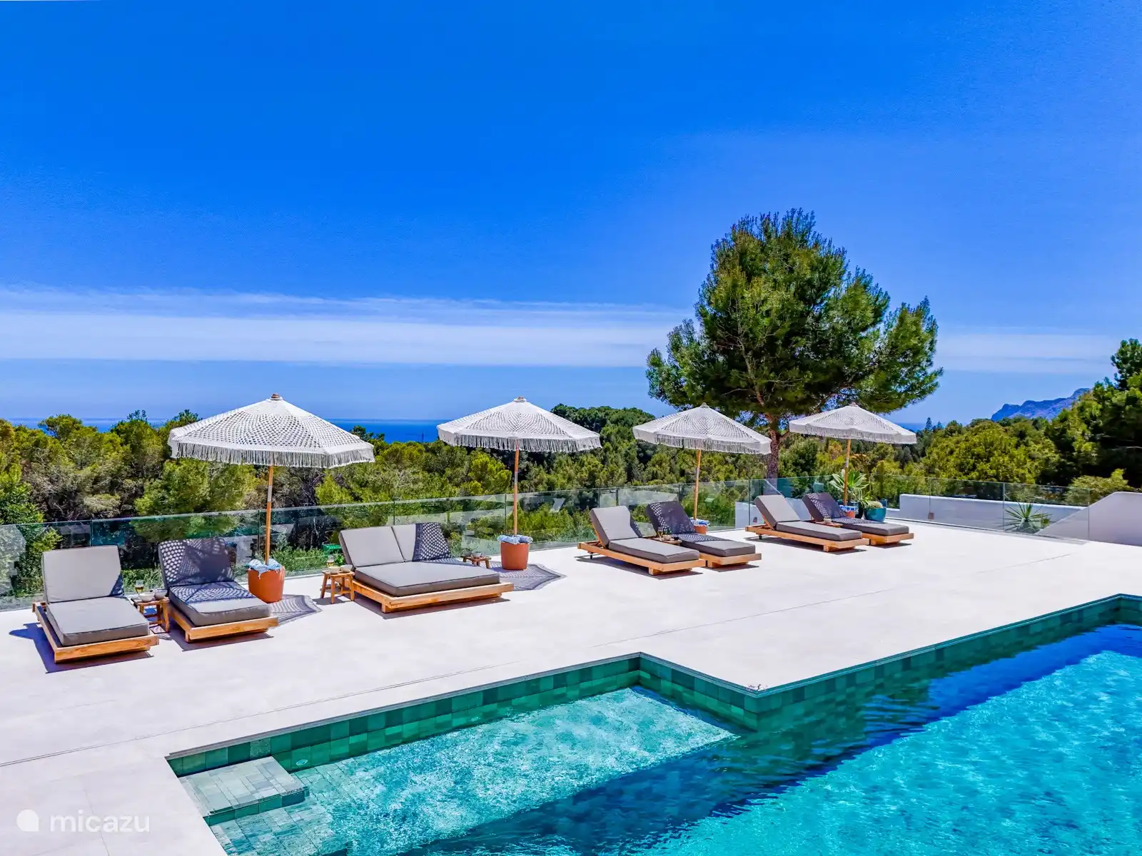 Neben den Lounge-Betten verfügt die großzügige Terrasse auch über einen separaten Lounge-Sitzbereich rund um den Pool.