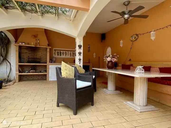 Cocina exterior con barbacoa y mesa grande