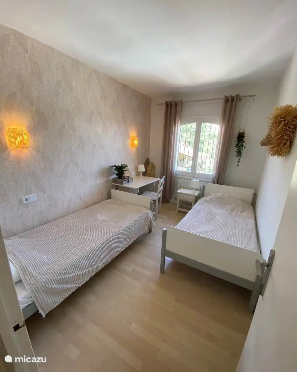 Bedroom with two single beds and a desk