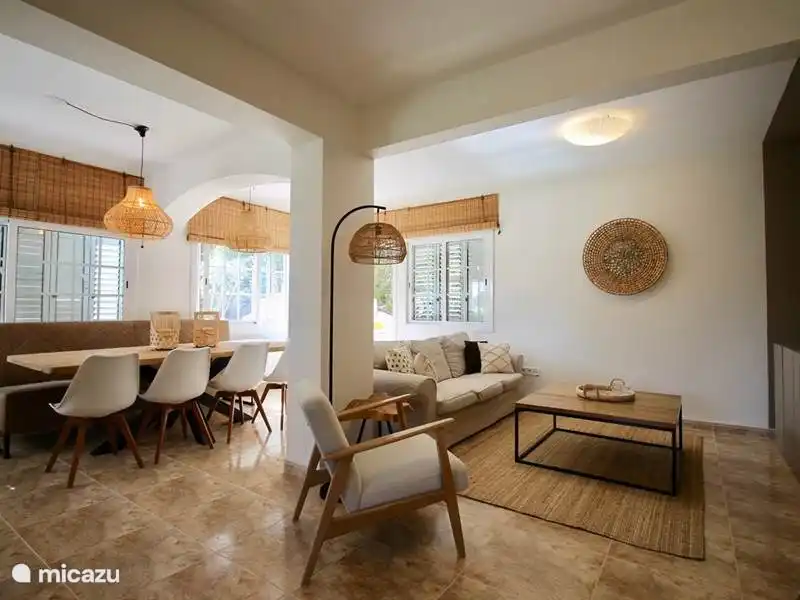 Living room in Ibiza style with dining room table and separate sitting area