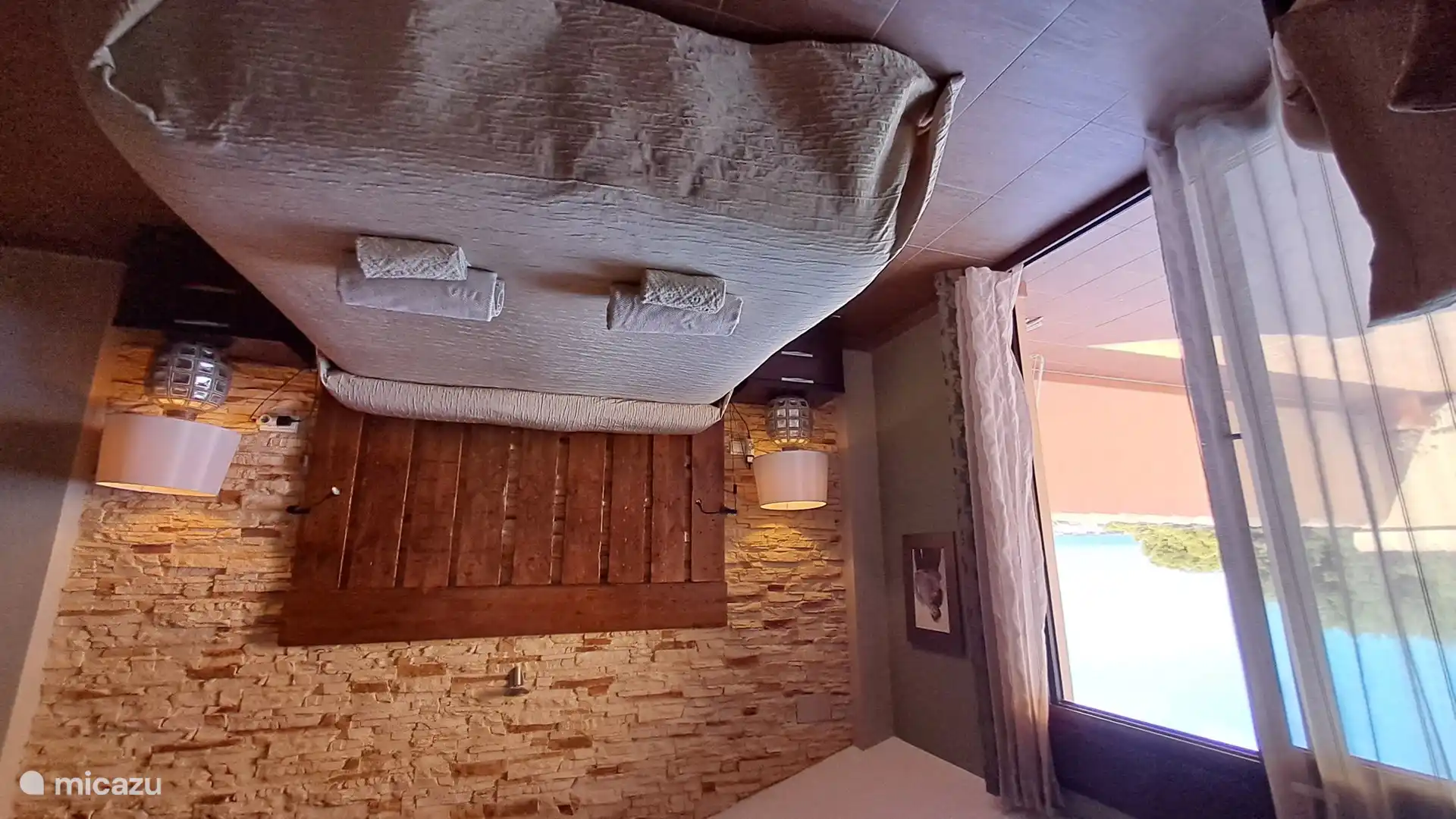 Im Obergeschoss Schlafzimmer mit Doppelbett und Zugang zur Terrasse im Obergeschoss.