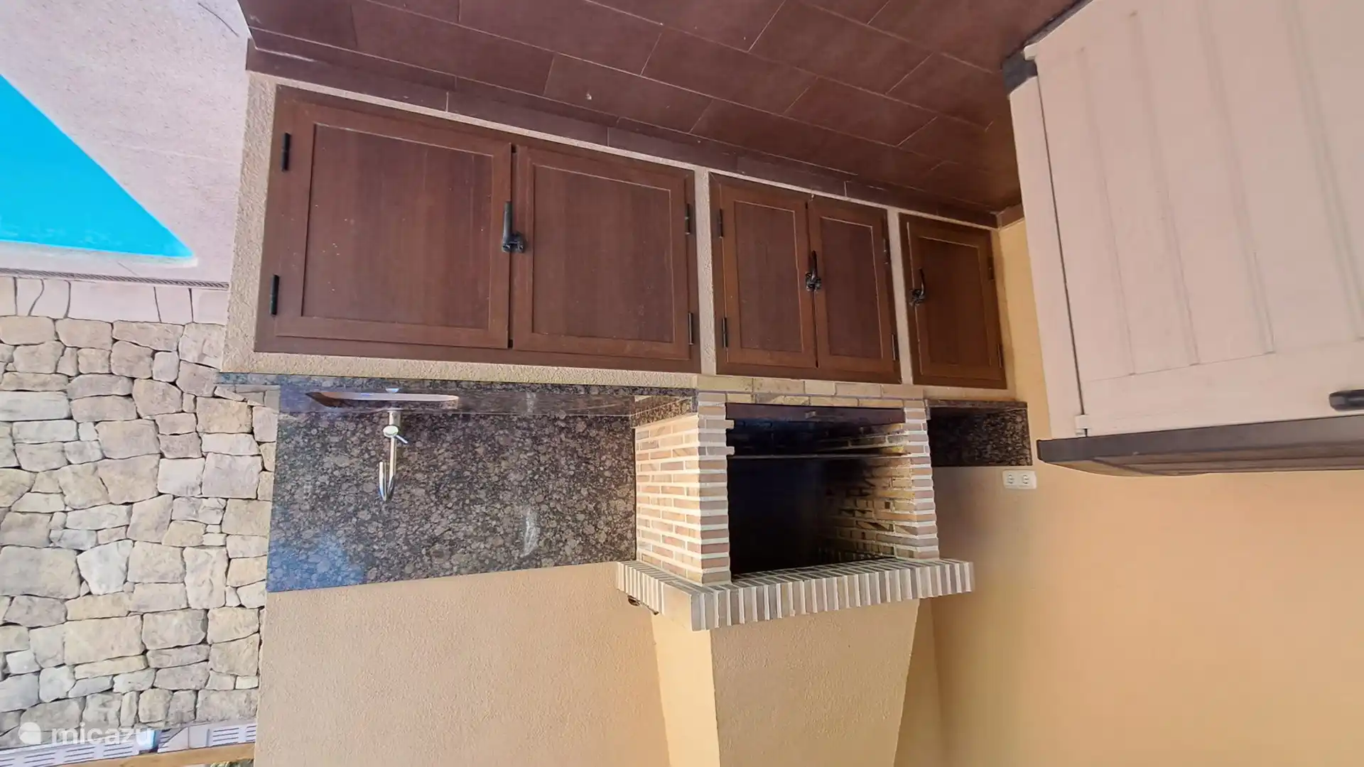 Grill-Außenküche. Dahinter befindet sich eine weitere Toilette.