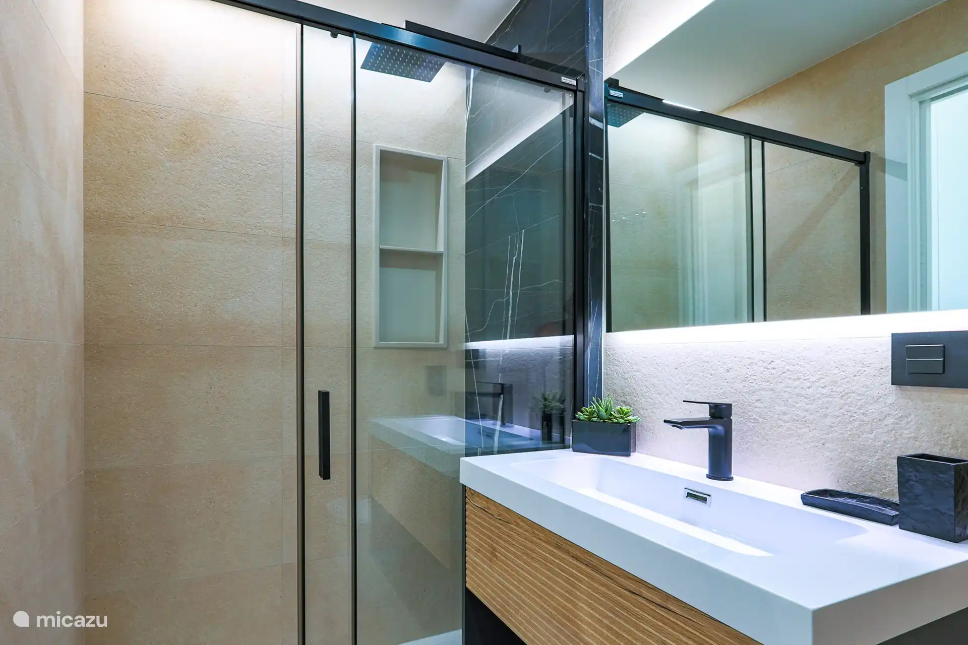 Une salle de bains élégante et moderne avec une douche à l’italienne spacieuse.