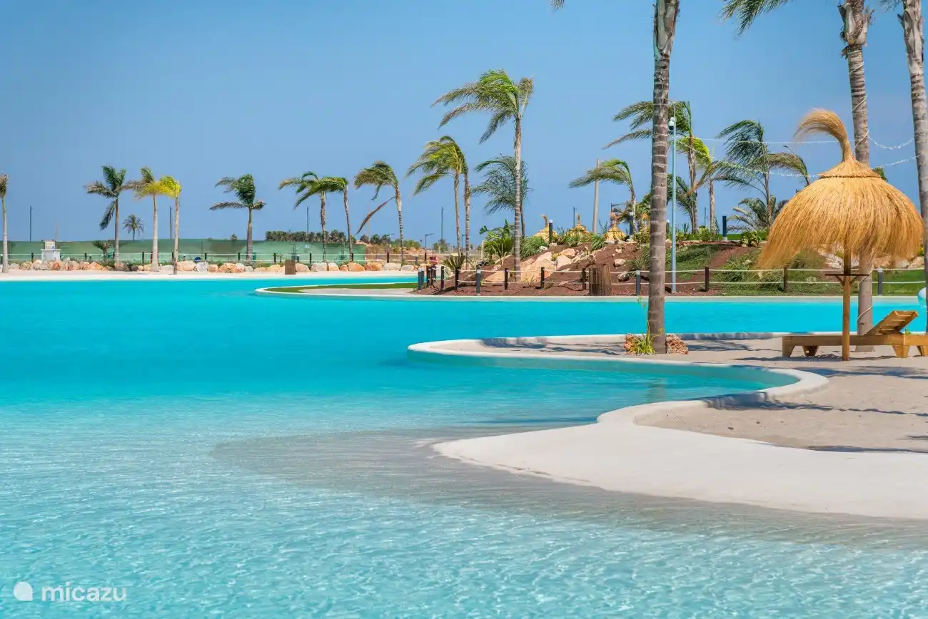 La surface calme du lac, entourée d’arbres verdoyants, crée une atmosphère sereine et paisible. 