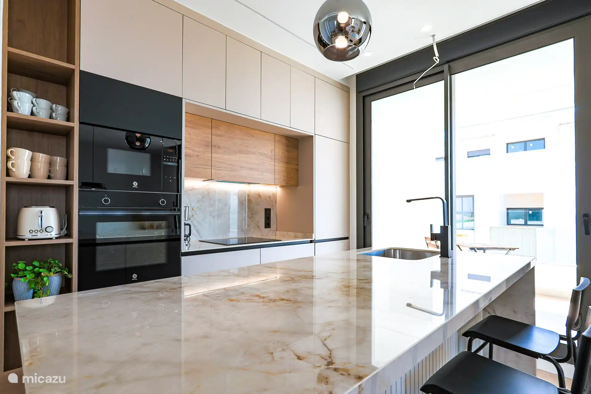 Cette cuisine moderne est un véritable délice pour l’amateur de cuisine. Le magnifique comptoir en pierre naturelle ajoute un look luxueux et offre un espace de travail spacieux pour toutes vos aventures culinaires. L’aménagement ouvert crée une atmosphère accueillante. 