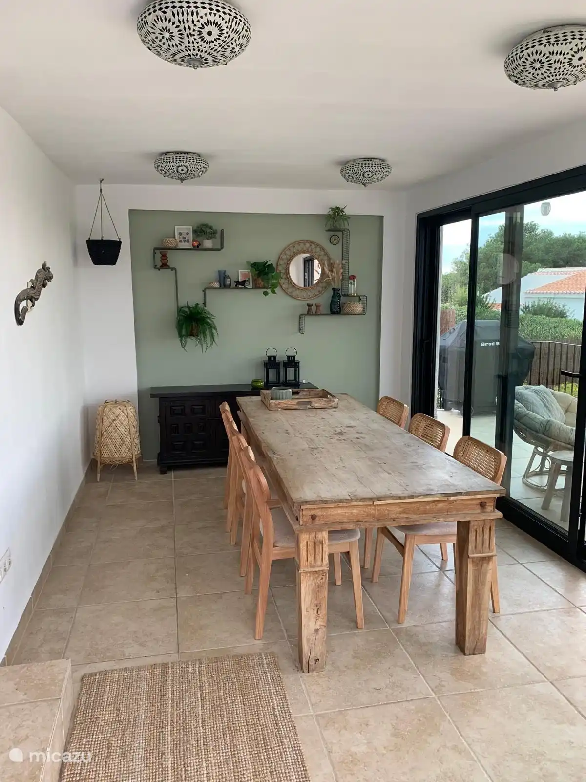 Innenterrasse mit Esstisch und Schiebetüren.