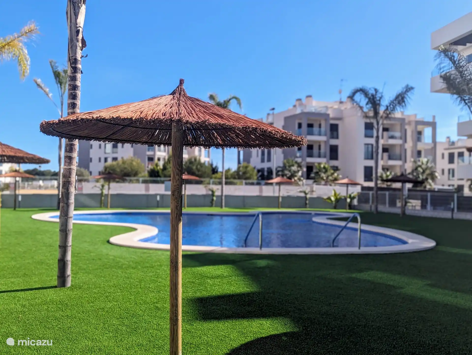 Der Swimmingpool liegt wunderschön in voller Sonne, umgeben von wunderschönen Palmen, die eine tropische Atmosphäre bieten. Neben dem großen Swimmingpool gibt es auch ein separates Kinderbecken, ideal für die Kleinen zum sicheren Spielen und Genießen.