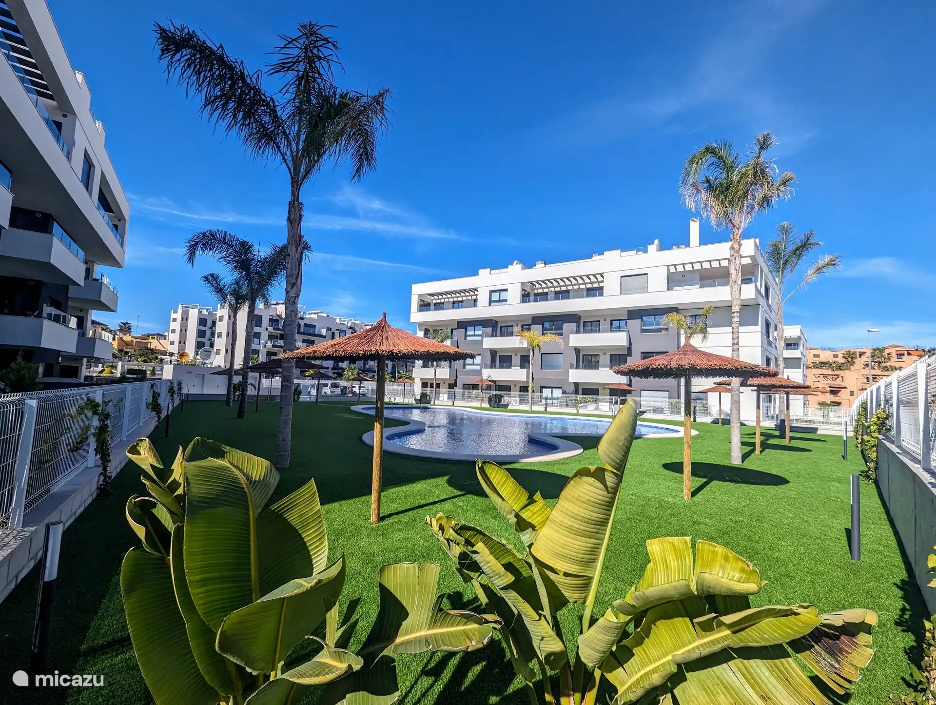 Der Swimmingpool liegt wunderschön in voller Sonne, umgeben von wunderschönen Palmen, die eine tropische Atmosphäre bieten. Neben dem großen Swimmingpool gibt es auch ein separates Kinderbecken, ideal für die Kleinen zum sicheren Spielen und Genießen.