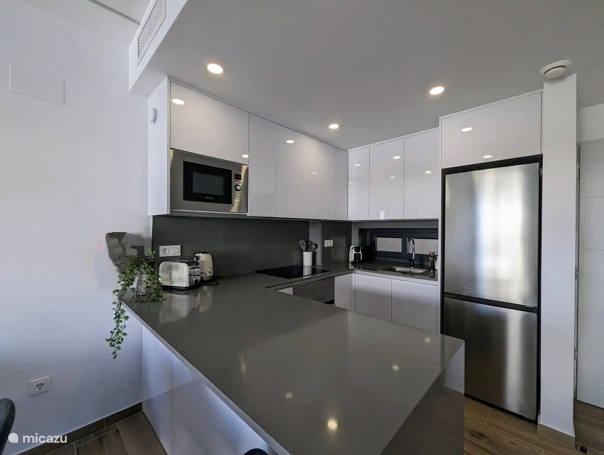 Die offene Küche mit Halbinsel ist das Herzstück des Hauses. Die Halbinsel bietet nicht nur zusätzlichen Arbeitsbereich, sondern schafft auch einen gemütlichen Ort zum Zusammenkommen beim Kochen. Die Küche ist modern und komplett mit allen notwendigen Geräten ausgestattet.