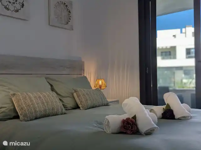 Luxe appartement met zwembadzicht huren in Spanje, Costa Blanca, Alicante - appartement Slaapkamer 2 heeft directe toegang tot het balkon, waar je kunt genieten van een prachtig uitzicht. De kamer is voorzien van een ruime inbouwkast en maakt gebruik van de tweede badkamer, die zich vlakbij bevindt. Een comfortabele en praktische ruimte voor een heerlijk verblijf.