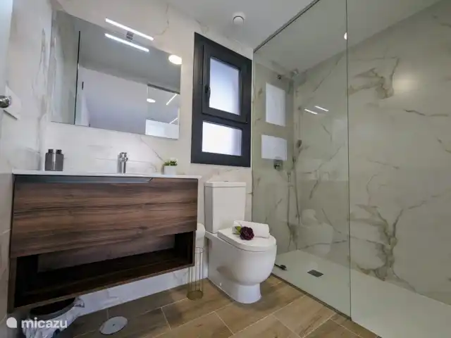 Luxe appartement met zwembadzicht huren in Spanje, Costa Blanca, Alicante - appartement De en-suite badkamer is modern ingericht en voorzien van een regendouche, stijlvol badmeubel en toilet, wat zorgt voor optimaal comfort en luxe.