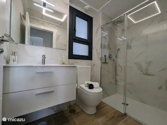 Luxe appartement met zwembadzicht huren in Spanje, Costa Blanca, Alicante - appartement Badkamer twee is nieuw en luxe, uitgerust met moderne voorzieningen zoals een ruime inloopdouche, stijlvol wastafelmeubel en toilet. De strakke afwerking en hoogwaardige materialen zorgen voor comfort en een eigentijdse uitstraling.