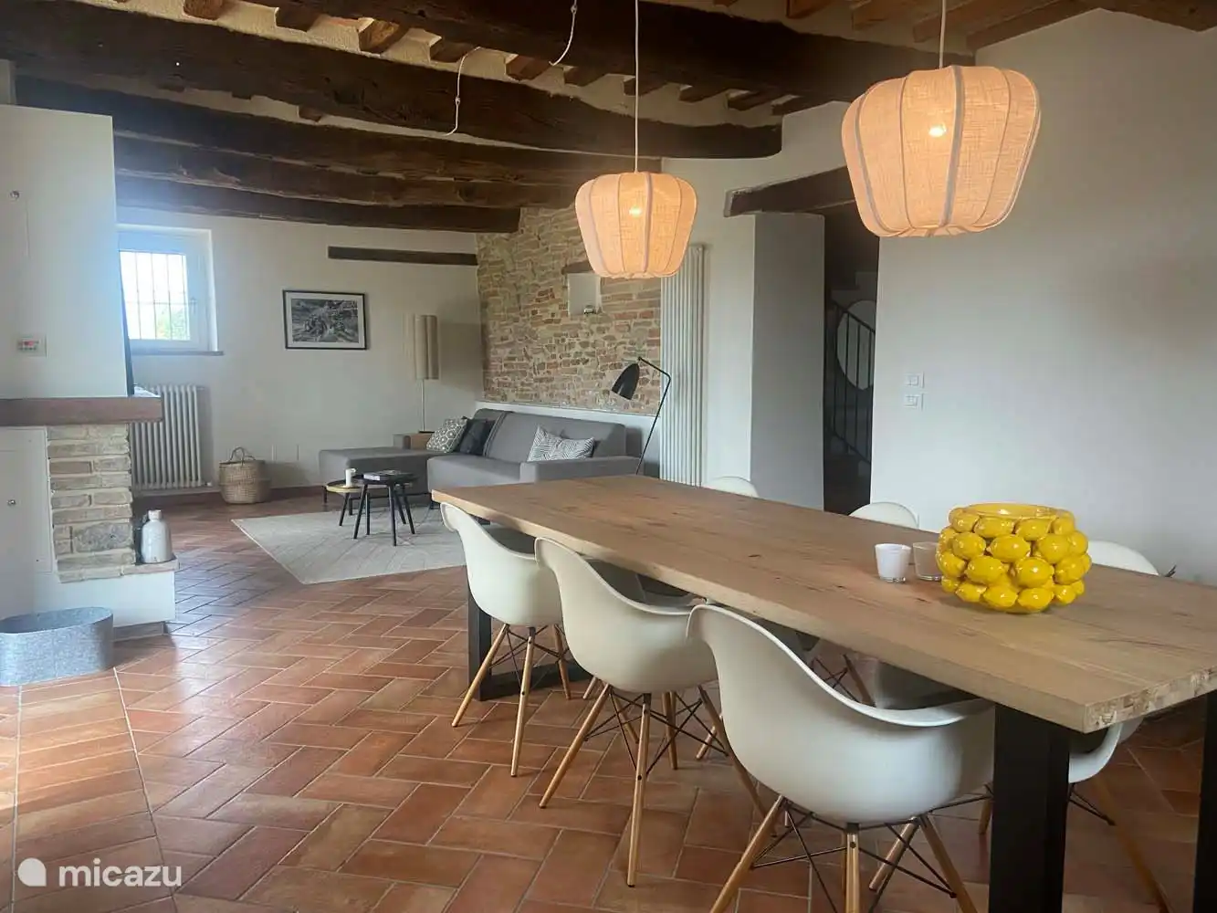 Das Zimmer verfügt über ein geräumiges Sofa mit Chaiselongue, einen Sessel und einen Esstisch für 6 Personen. Ein Kaminofen für den Winter rundet das Bild ab.