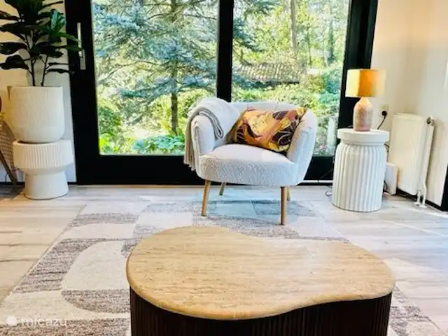 StayatSas Tiny House Pippa huren in Nederland, Gelderland, Doornspijk - chalet De ruime lichte woonkamer heeft veel ramen en uitzicht op de tuin rondom