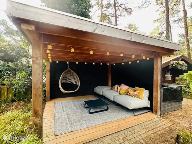 StayatSas Tiny House Pippa huren in Nederland, Gelderland, Doornspijk - chalet grote overdekte pergola met loungebank en hangstoel