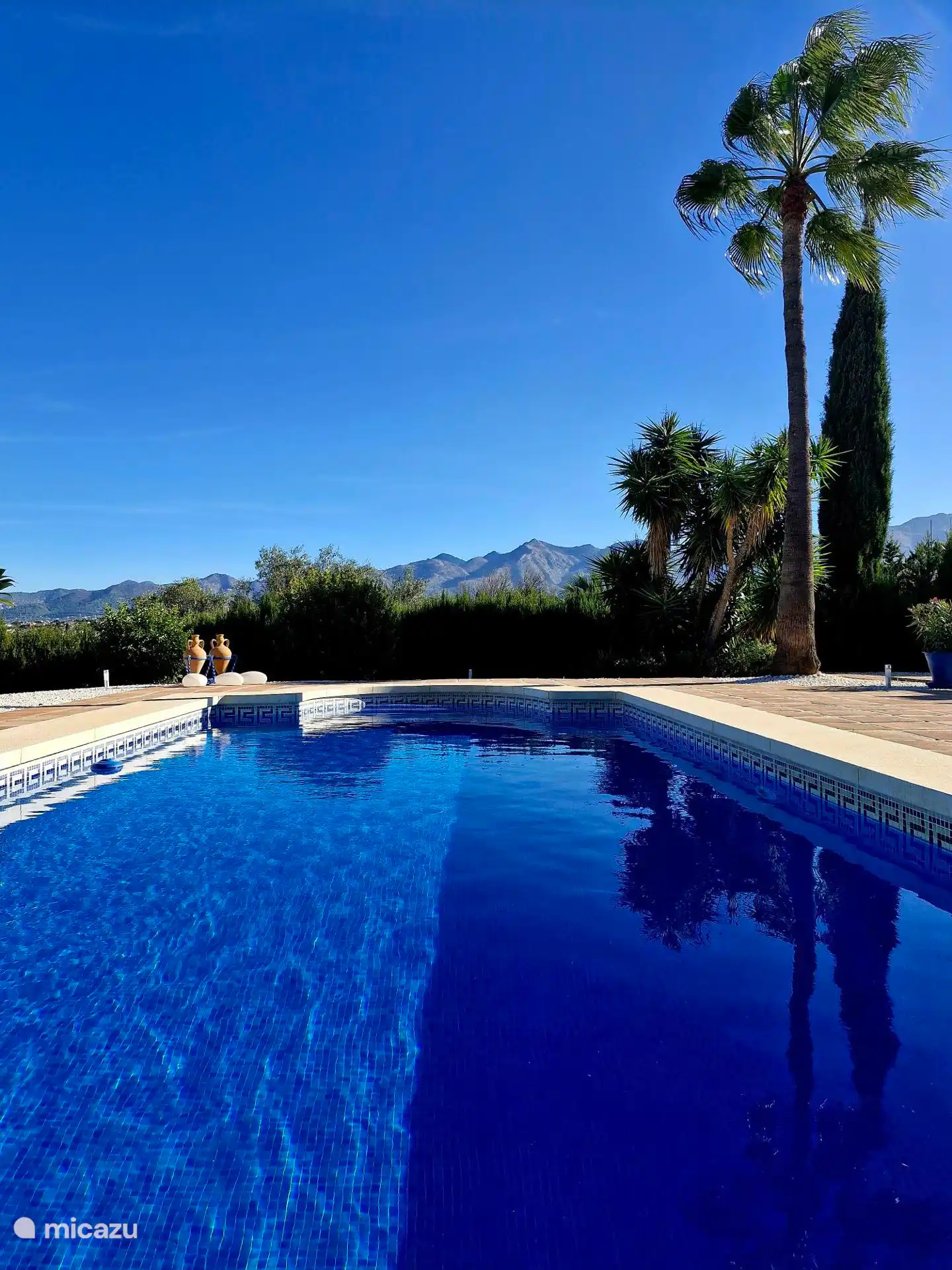 Unser Schwimmbad glitzert in der Sonne, mit der schönen Silhouette der Sierra de Mijas im Hintergrund.