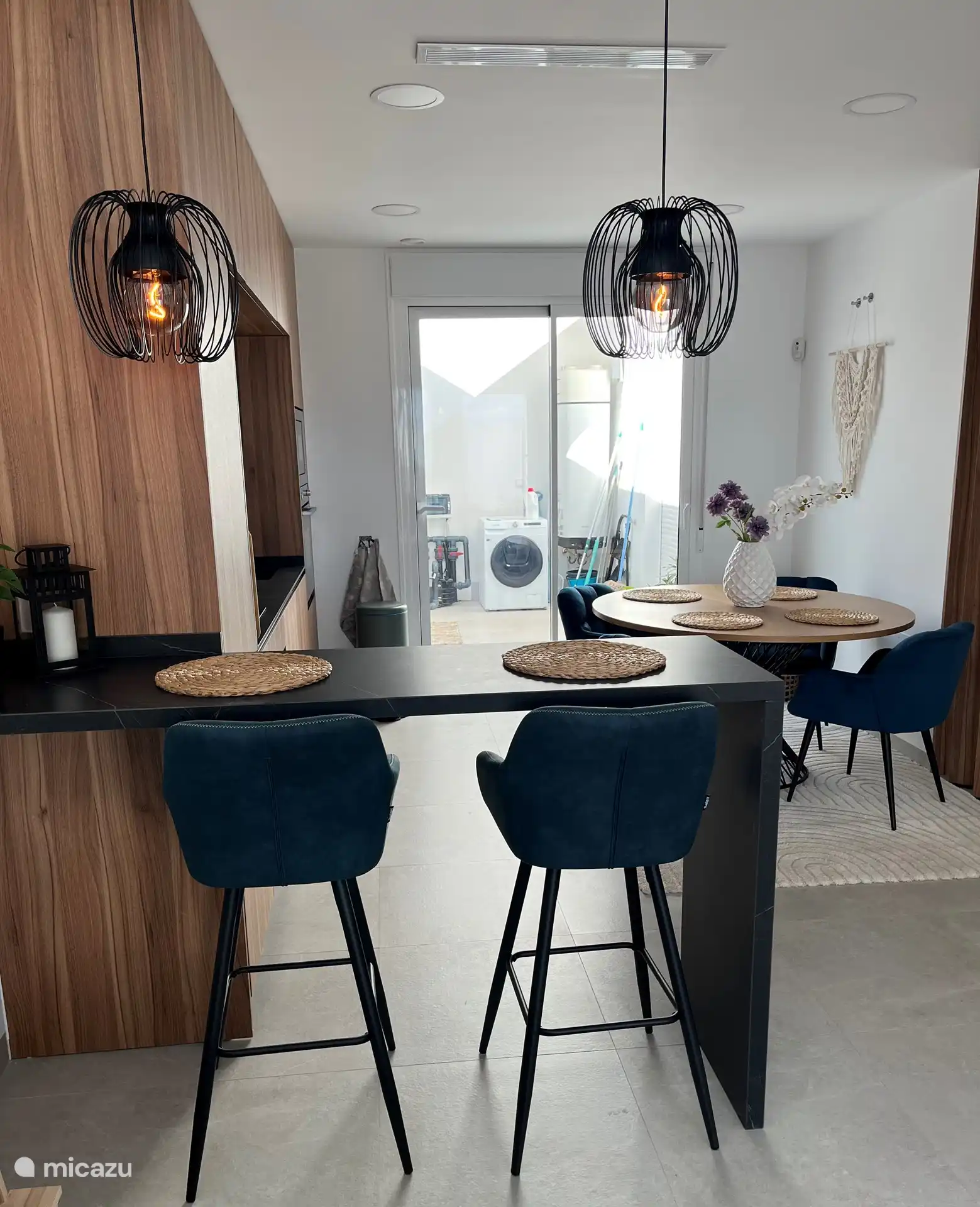 The breakfast bar, the dining table and a view of the patio. Doors have now been placed on the patio so that the washing machine and boiler can no longer be seen. 