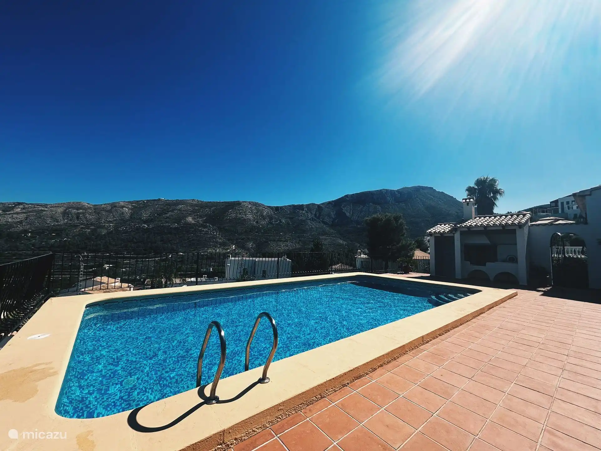 Swimmingpool mit Außenküche und Blick auf die Berge