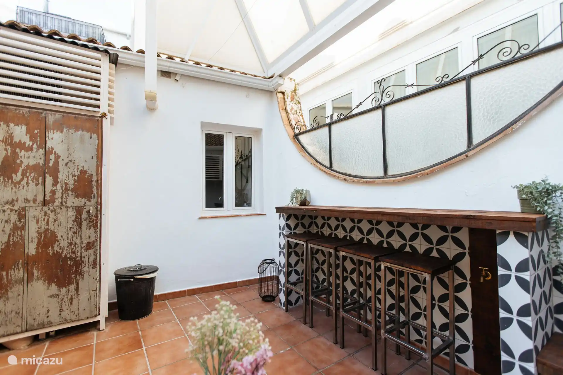 Le patio spacieux a beaucoup d’intimité et dispose d’un coin salon confortable avec une table de bar spacieuse avec 4 tabourets. 