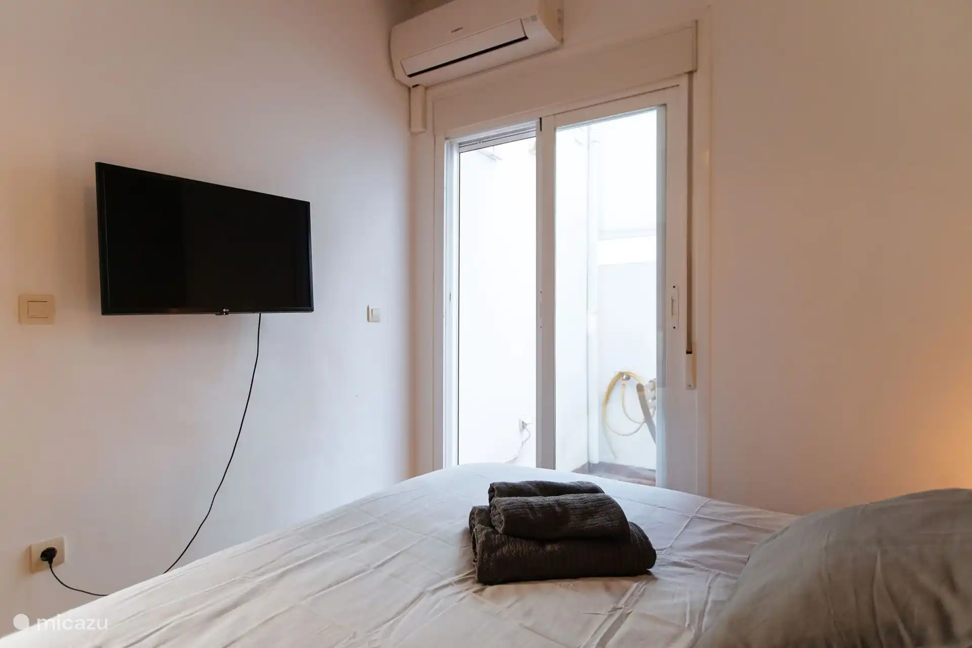 Vue sur le petit patio et la possibilité de regarder votre film ou série préféré depuis le lit.