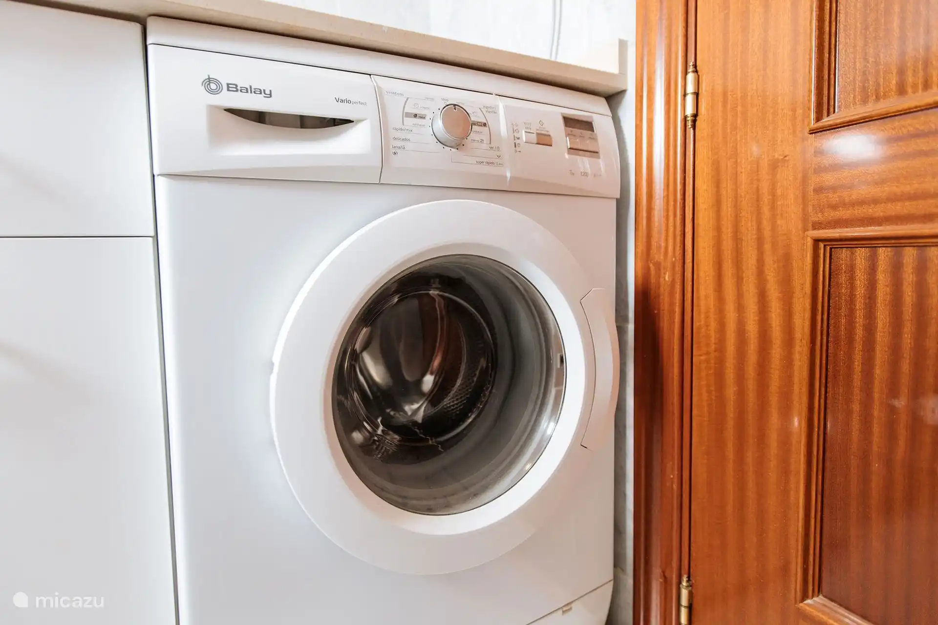 La machine à laver est située dans la salle de bain.