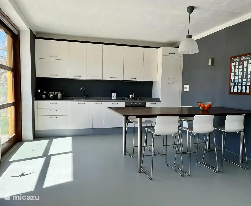 En la cocina abierta hay una mesa de bar con 6 taburetes. Práctico para el desayuno, las copas o la preparación de la cena, por ejemplo, con fantásticos ingredientes locales. 