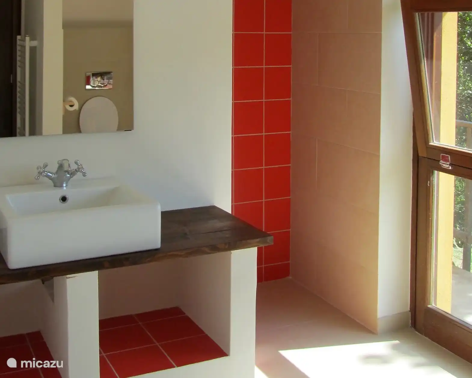 Hay dos baños grandes. Un baño tiene una bañera, el amplio baño de esta foto tiene una ducha, un lavabo y un inodoro. 