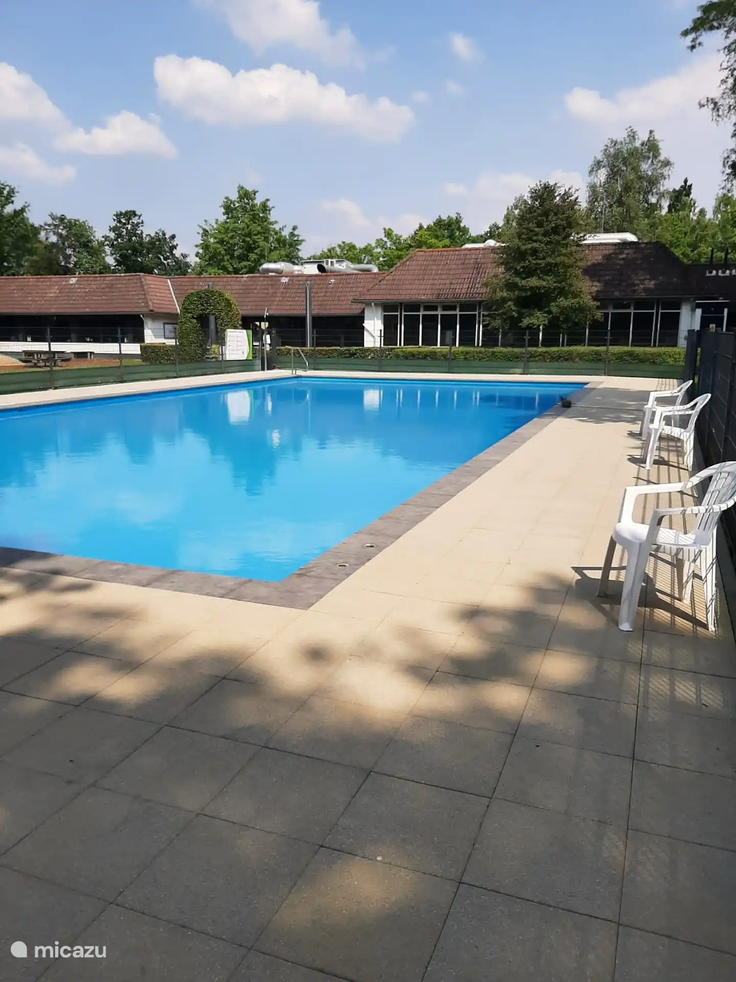 Freier Zugang zum Außenpool mit Liegestühlen und Liegewiese.