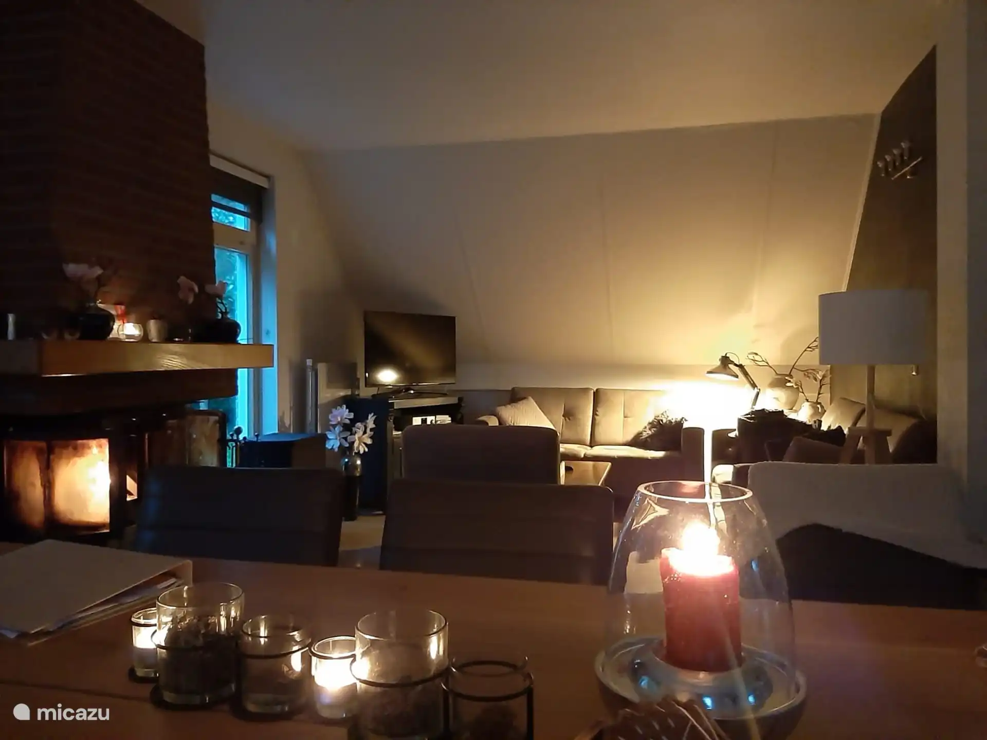 Geräumiges, gemütliches Wohnzimmer mit Kamin und Kerzen auf dem Esstisch während der Wintermonate.