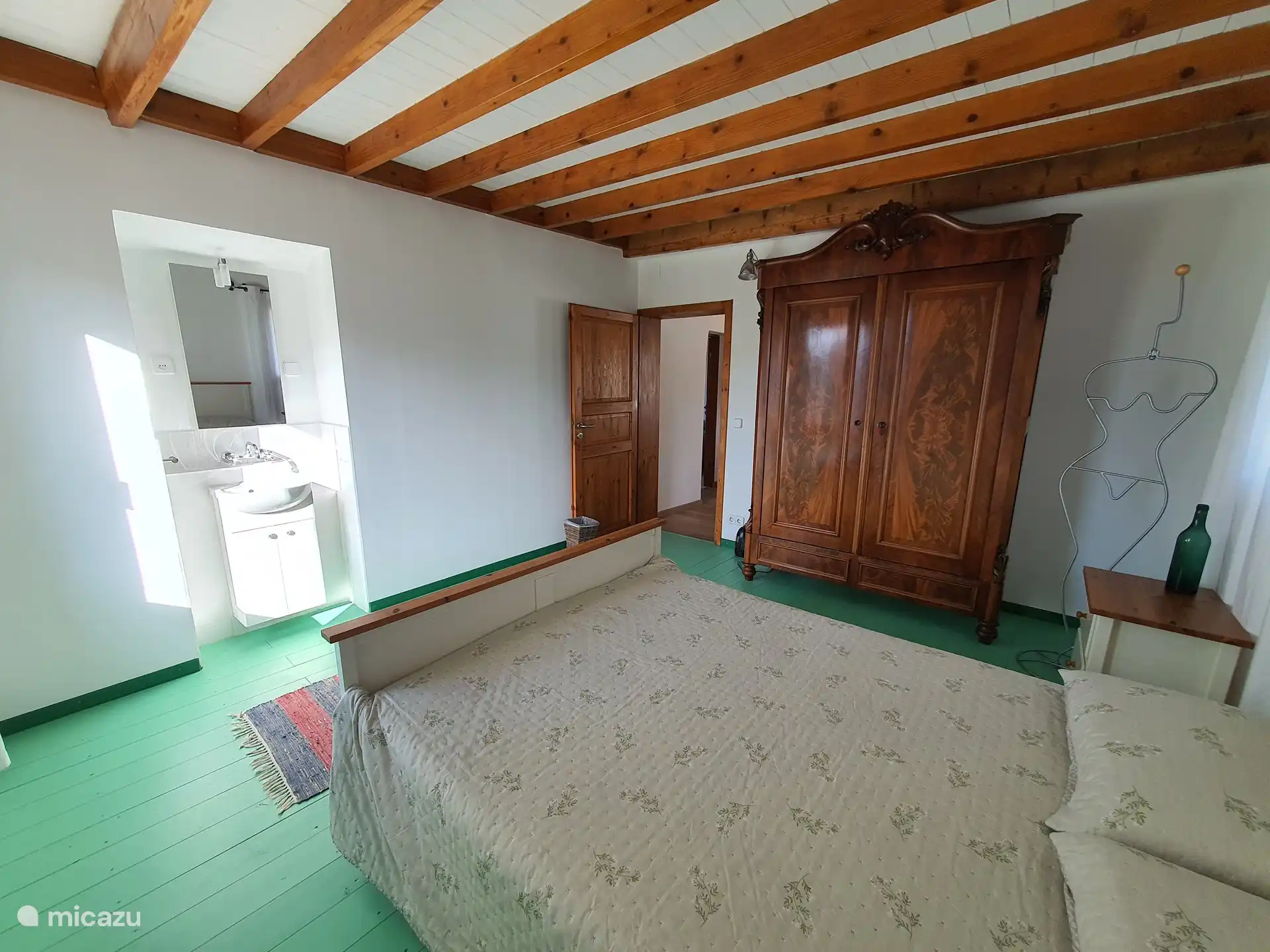 Schlafzimmer 1 mit Blick auf Waschbecken und antiken Schrank