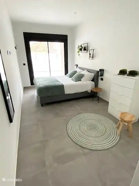 Slaapkamer met toegang naar terras en rolluiken