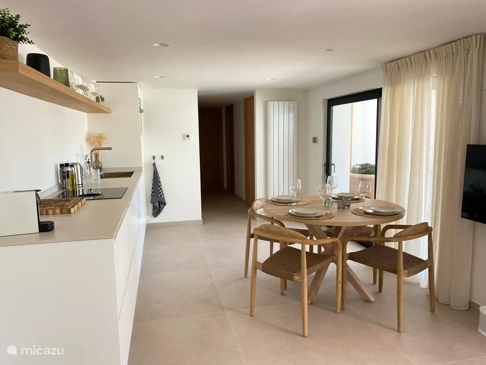 Mesa de comedor con cocina en la planta baja y puerta corredera a terraza y piscina