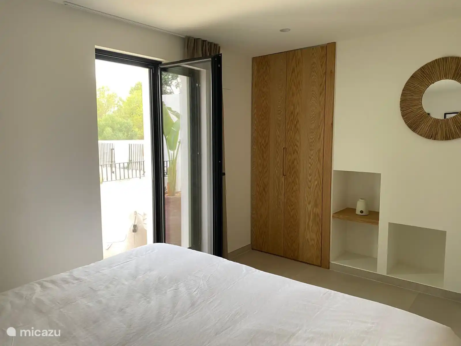 Dormitorio 2 en la planta baja con puerta a la terraza y piscina