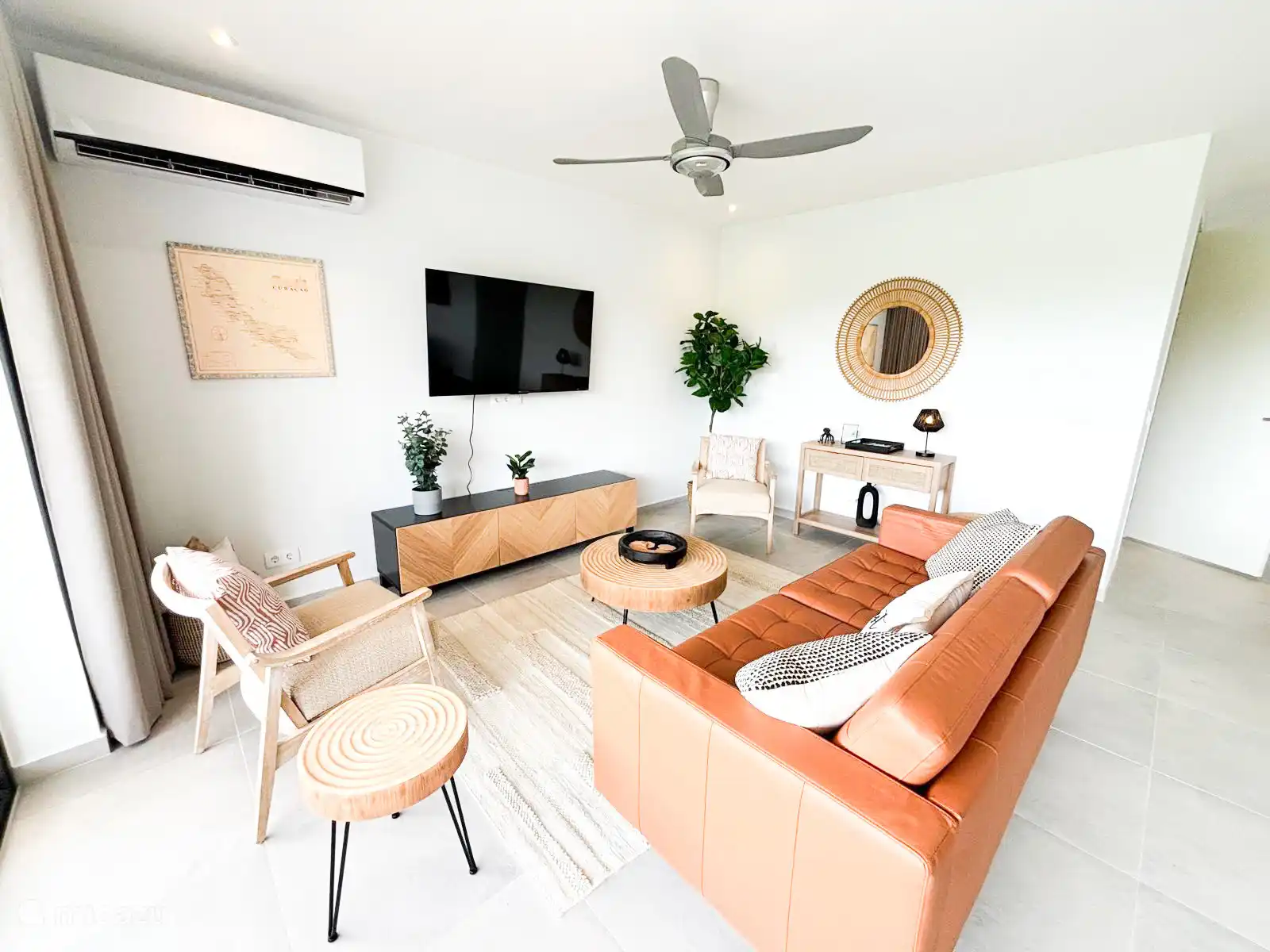 Geräumiges Wohnzimmer mit Ventilator und Klimaanlage und Großbildfernseher