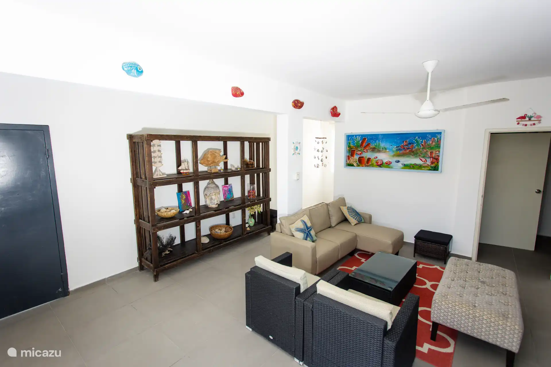 Gemütlicher Wohnbereich mit vom Meer inspiriertem Dekor, perfekt zum Zusammenkommen nach einem Strandtag.