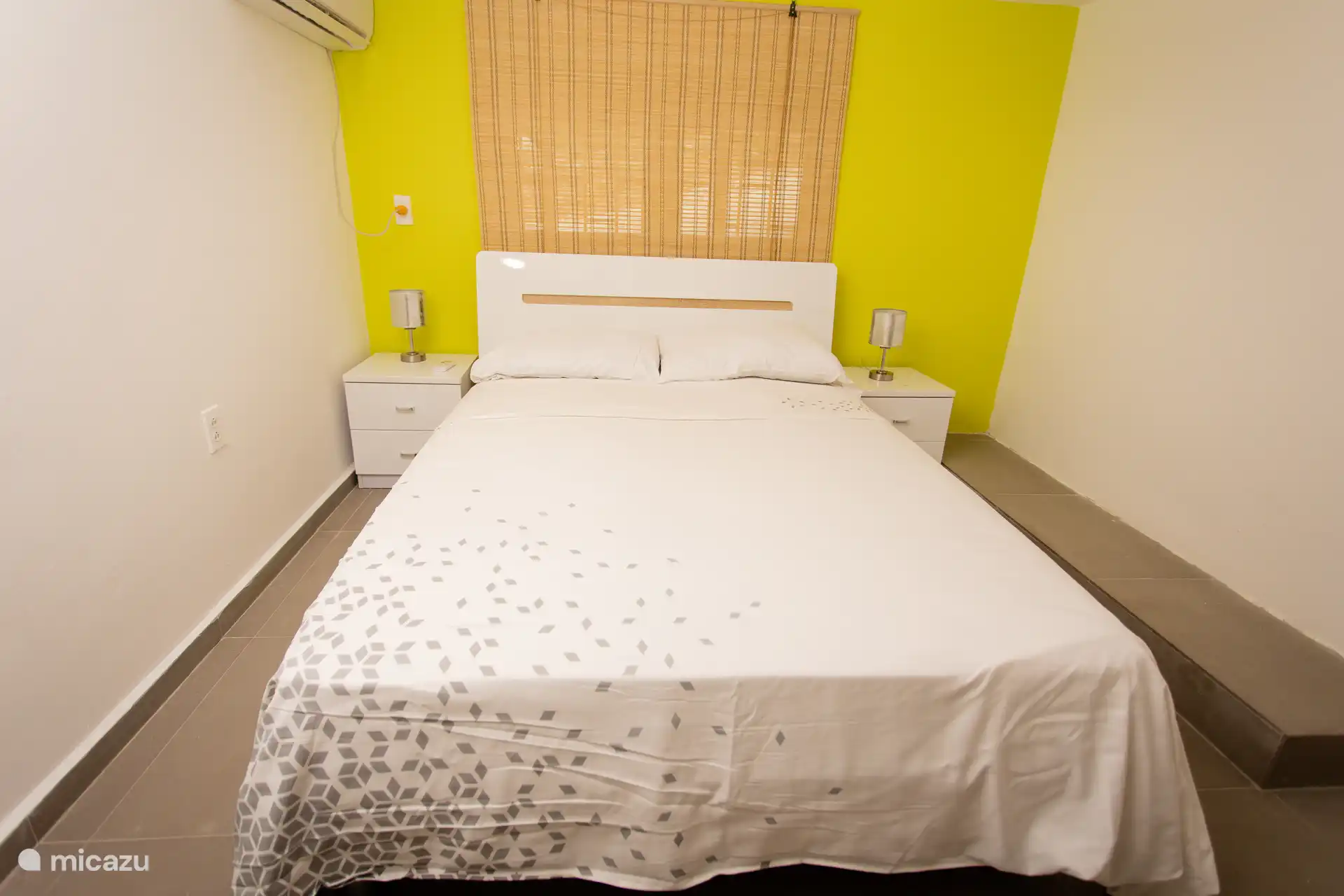 Komfortables Doppelbett mit kräftiger gelber Wand- und Klimaanlage.