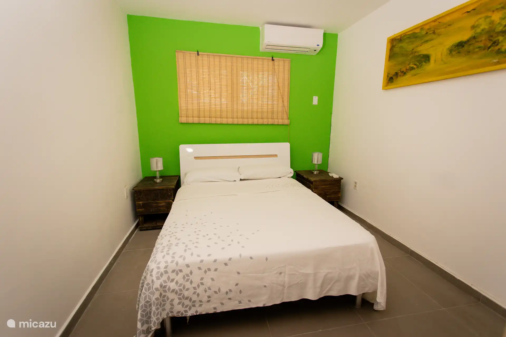 Helles und fröhliches Schlafzimmer mit Doppelbett und einem Hauch von Grün für einen frischen, entspannenden Look.