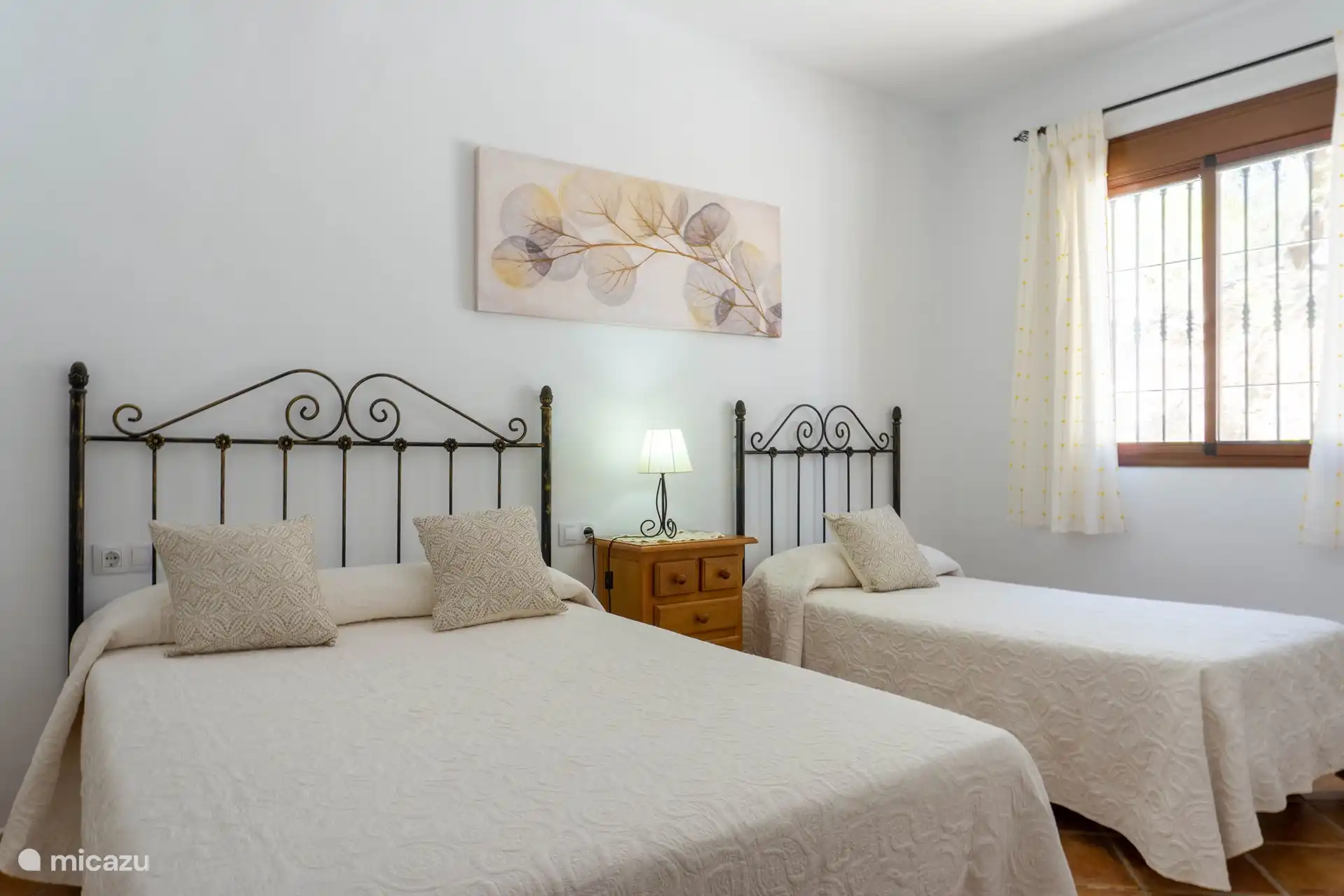 Geräumiges und helles Schlafzimmer mit Doppelbett und Einzelbett.