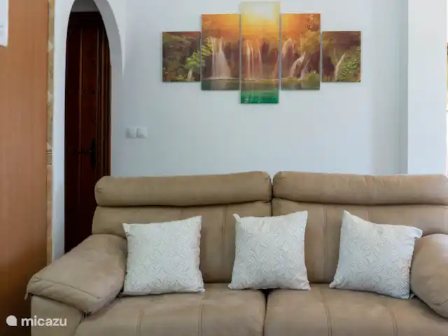 La Casita del Garrobo en España, Costa del Sol, Comares - casa rural / cabaña Cómodo sofá y detrás el acceso a las habitaciones y el baño.
