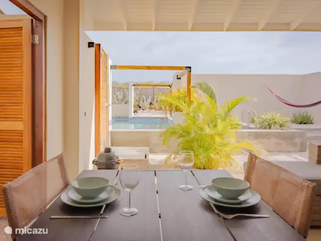 Location de Vacances Curaçao, Banda Abou (ouest), Hofi Abou, maison de vacances - Bunitesa di bida - Kas Iquana terrasse donnant sur le jardin avec piscine que vous partagez avec jusqu’à 3 autres personnes