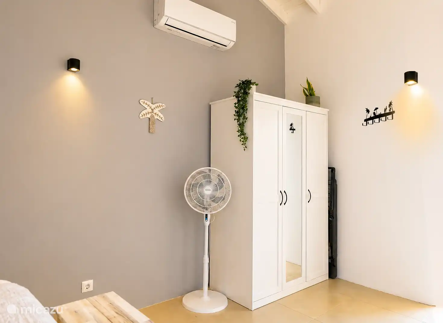 Dans la chambre, il y a un climatiseur, un ventilateur mobile, un placard et un séchoir