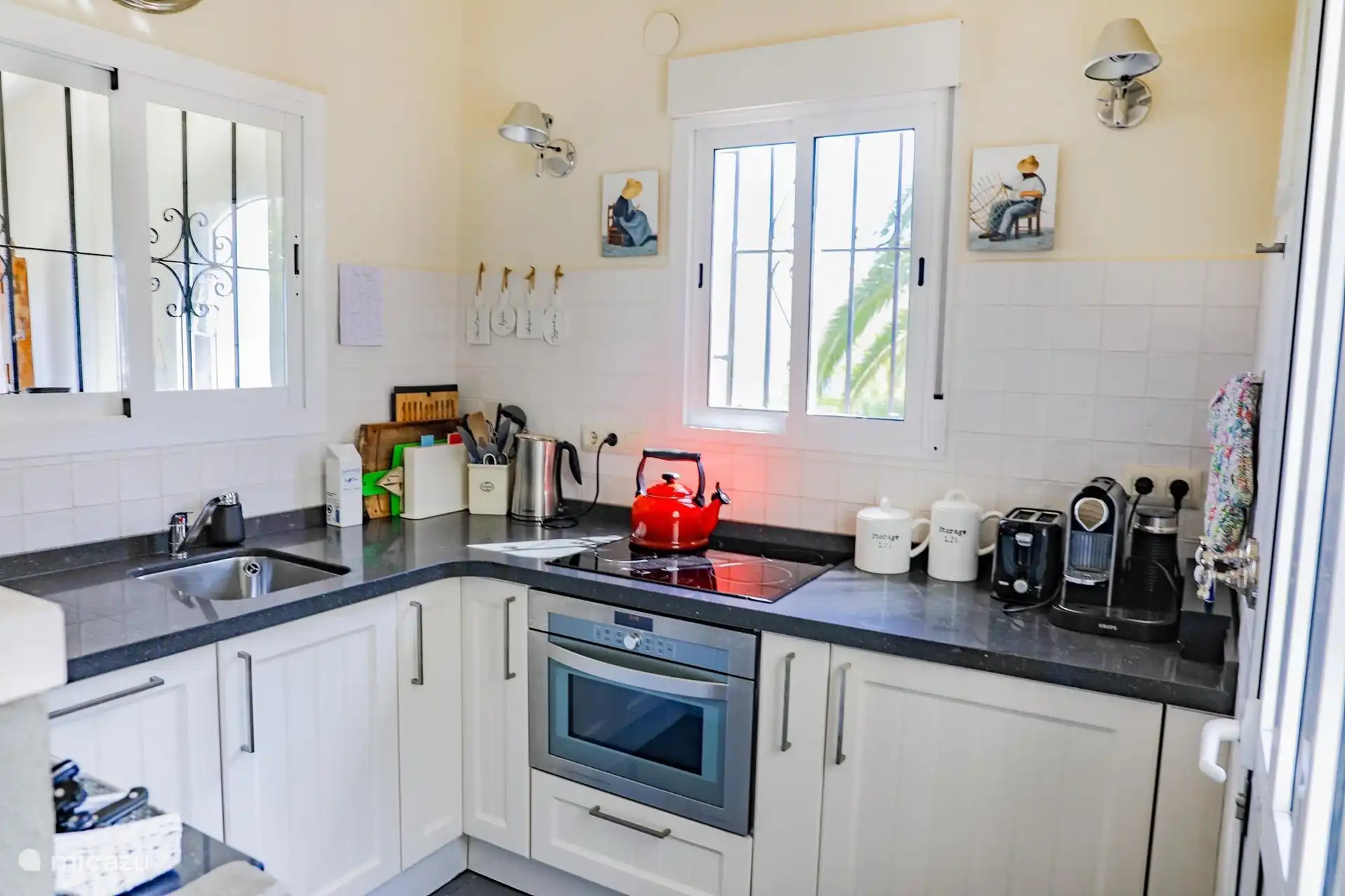 De compacte open keuken is van alle gemakken voorzien en vormt het hart van het huis. Licht, overzichtelijk en direct verbonden met de leefruimte en de veranda.