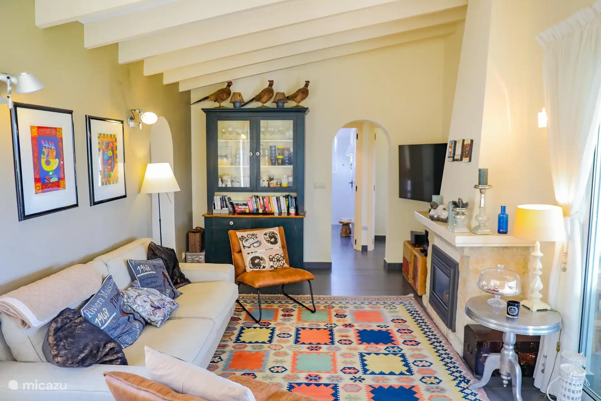 De woonkamer is licht en ruim opgezet, met warme kleuren, persoonlijke accenten en verschillende plekken om samen te zijn of je even terug te trekken