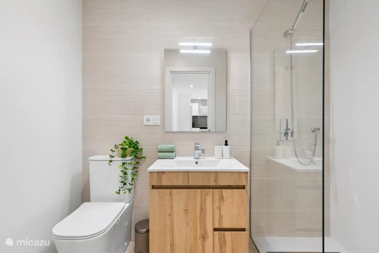 Das Badezimmer mit WC, Dusche und Waschbecken 