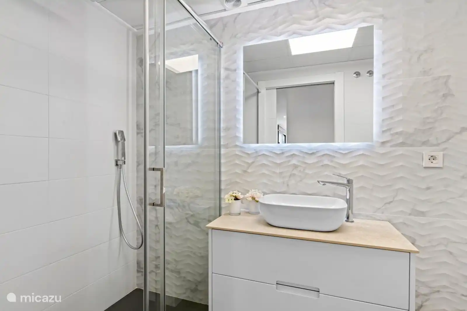 das Badezimmer mit Dusche, WC und Waschbecken 